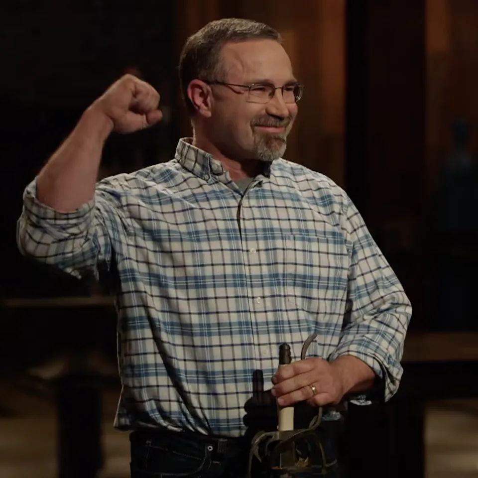 Ron Hardman, founder of Kilroy’s Workshop, raising a fist in celebration on the Forged in Fire set with his finished blade.